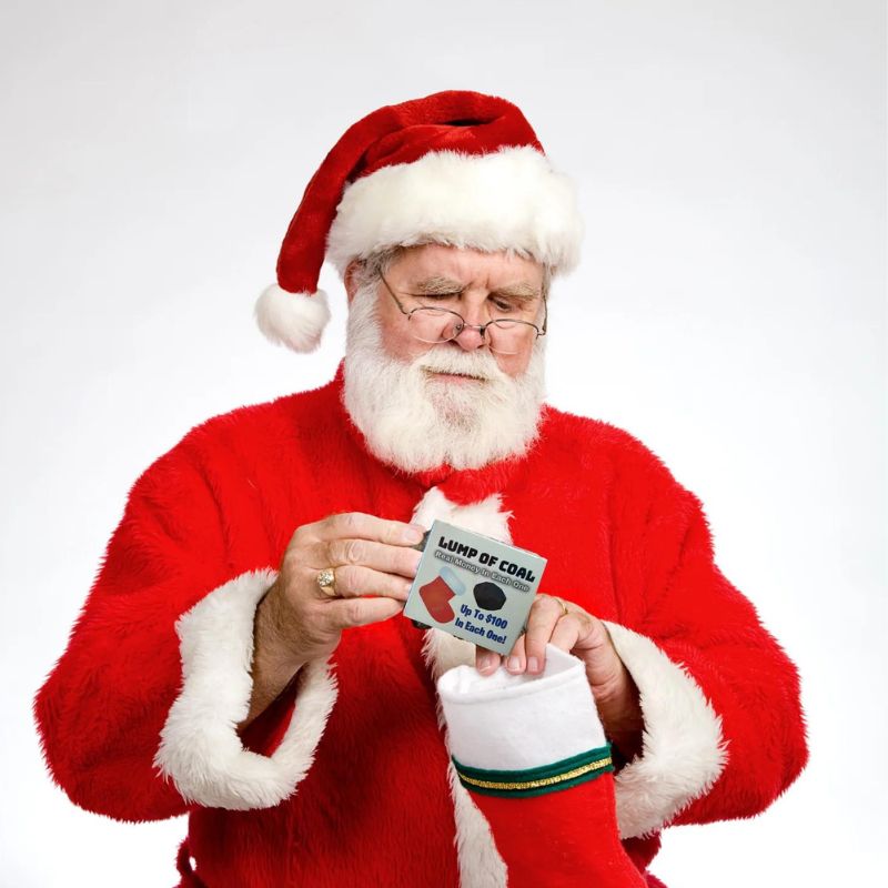 Santa putting a lump of money soap coal into a Christmas stocking